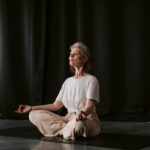 Senior woman practicing yoga in seated position indoors, focusing on mindfulness.